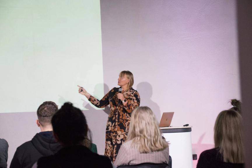 PhD Beata Iwanicka during her speech - talking to the microphone and pointing up