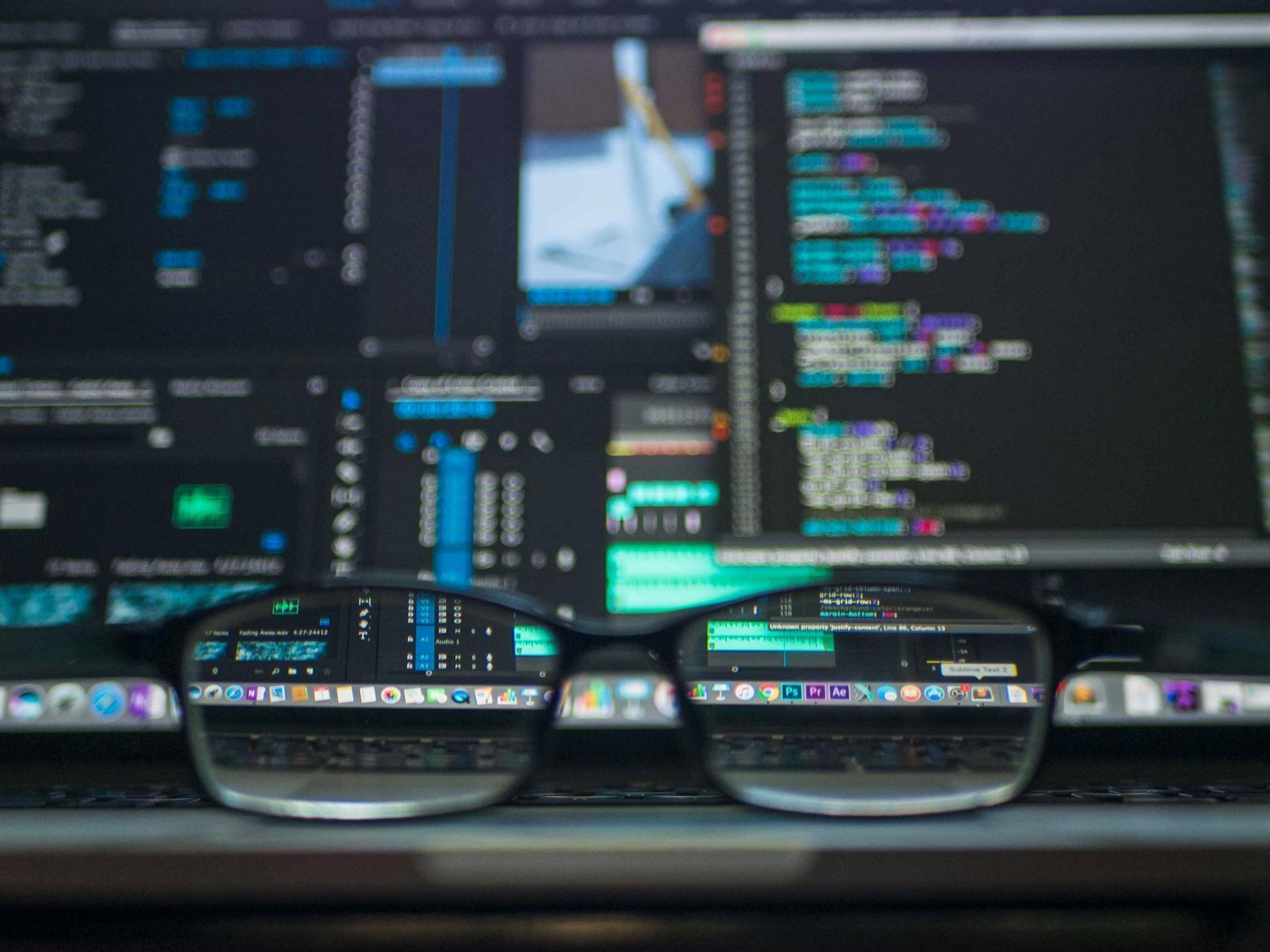 eyeglasses in front of a computer screen displaying data