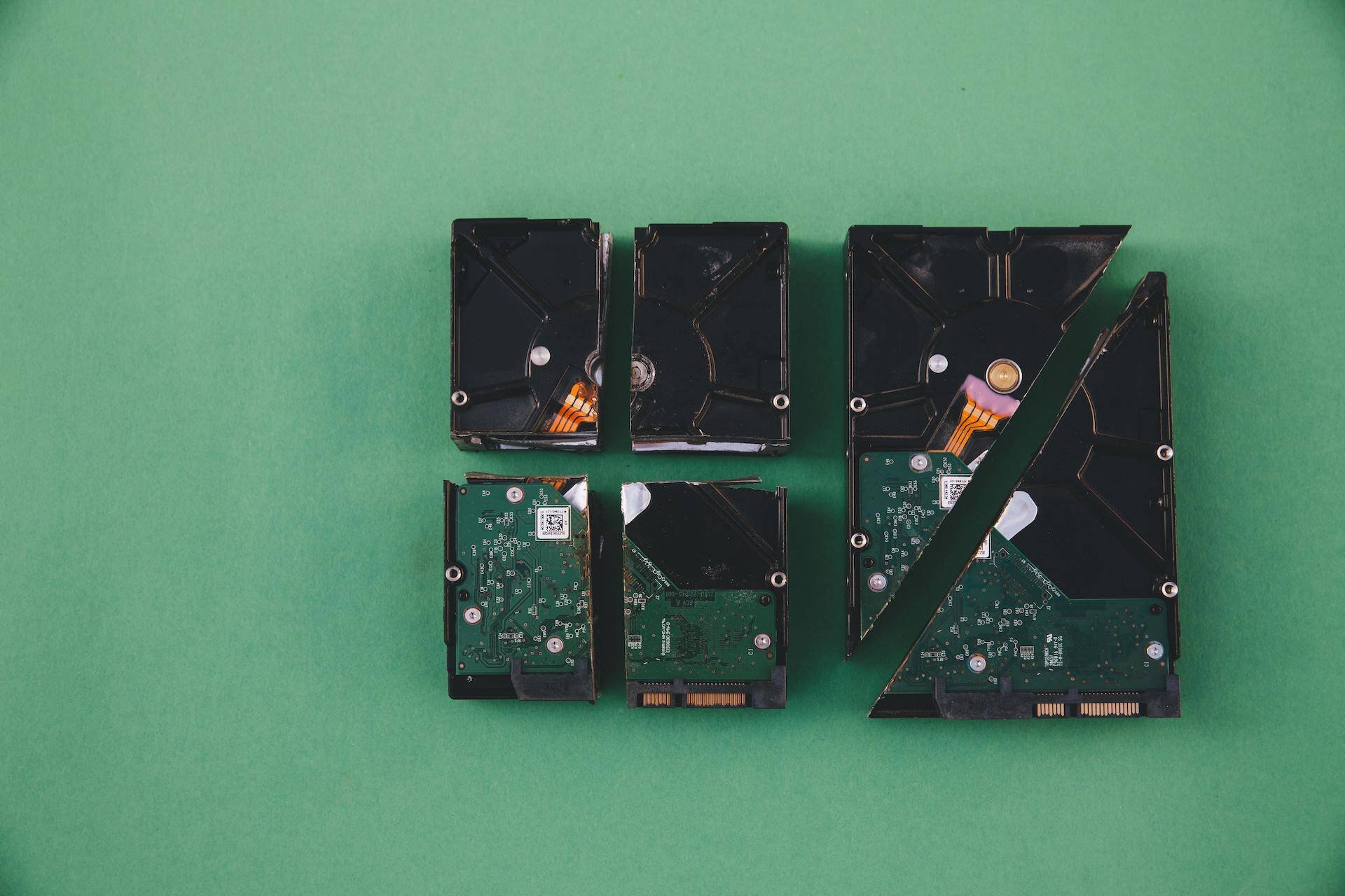 a hard drive cut up into pieces on a green background